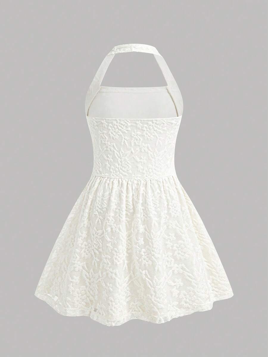 Black sleeveless halter polka dot mini dress for tween girls featuring a high waist and flared hem