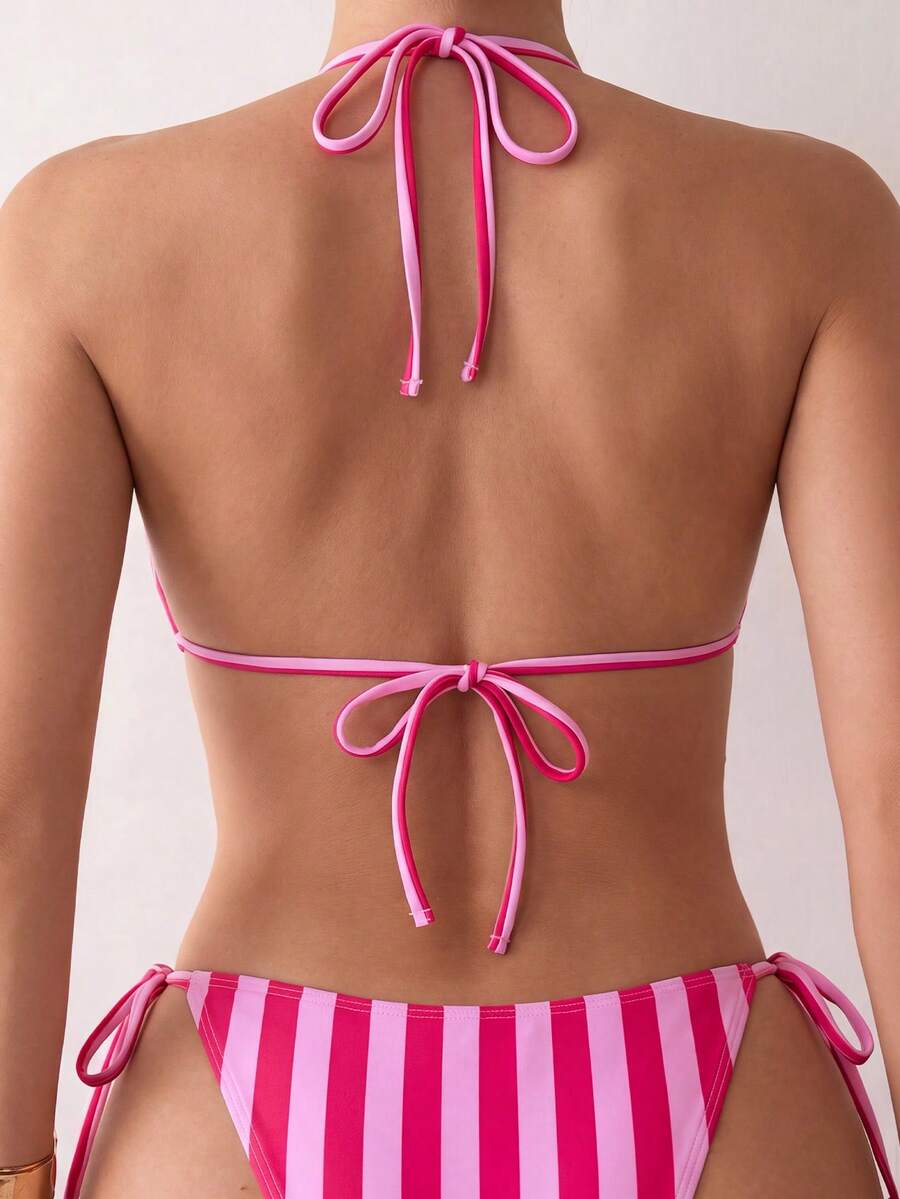 Women's black two-piece bikini set featuring a halter neck with a colorful sun pendant, triangle cups, and high-cut tie-side bottoms.