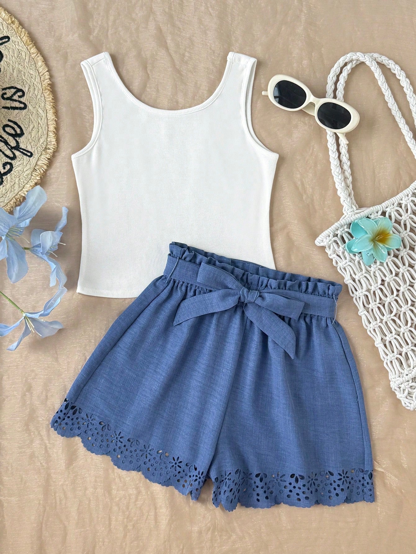 Tween girl wearing a casual 2-piece set featuring a black rib-knit scoop neck tank top and leopard print paperbag waist shorts with a matching belt.