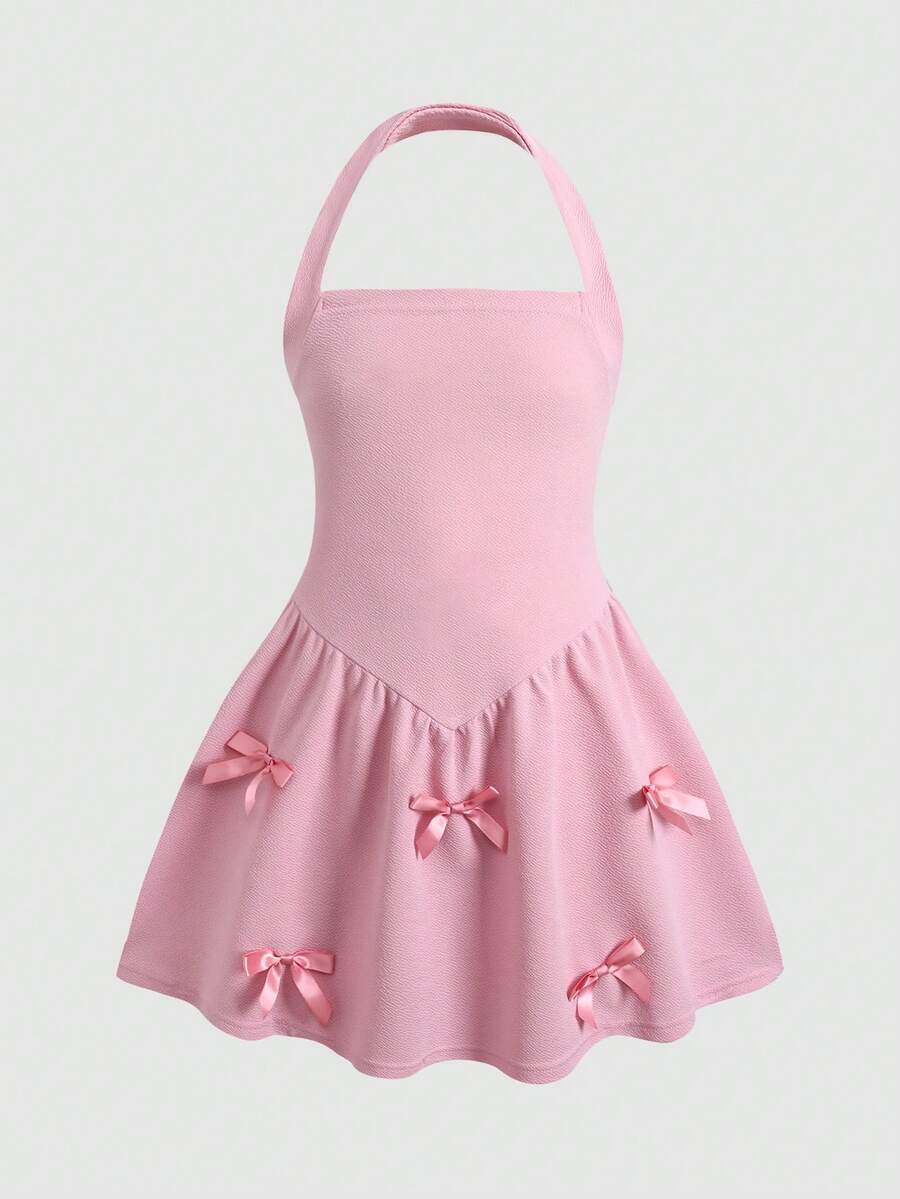 Black sleeveless halter polka dot mini dress for tween girls featuring a high waist and flared hem