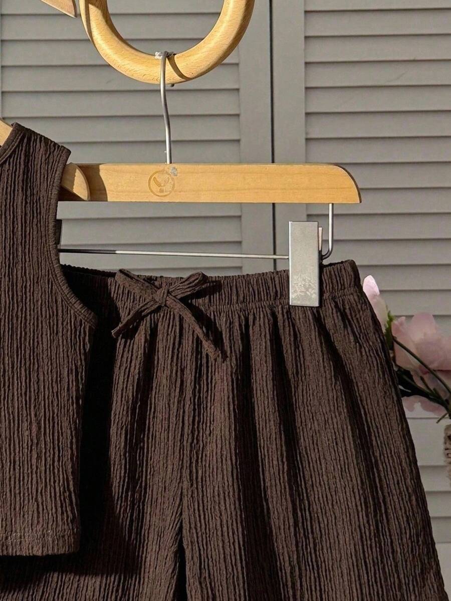 Tween girl 2-piece summer set with a black and white sleeveless striped spaghetti strap tank top with ruffle details and matching casual shorts.