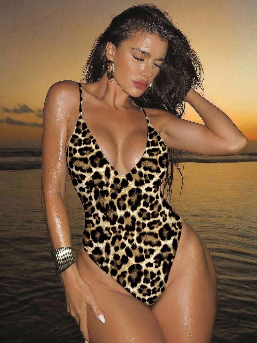 Women's black lace one-piece swimsuit featuring a deep V-neckline, spaghetti straps, backless tie-up detail, and thong bottom.