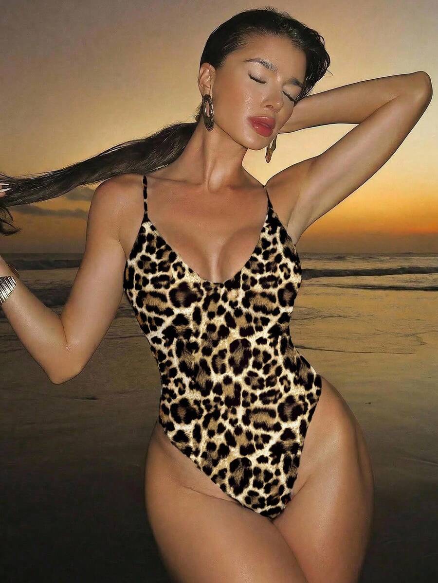 Women's black lace one-piece swimsuit featuring a deep V-neckline, spaghetti straps, backless tie-up detail, and thong bottom.