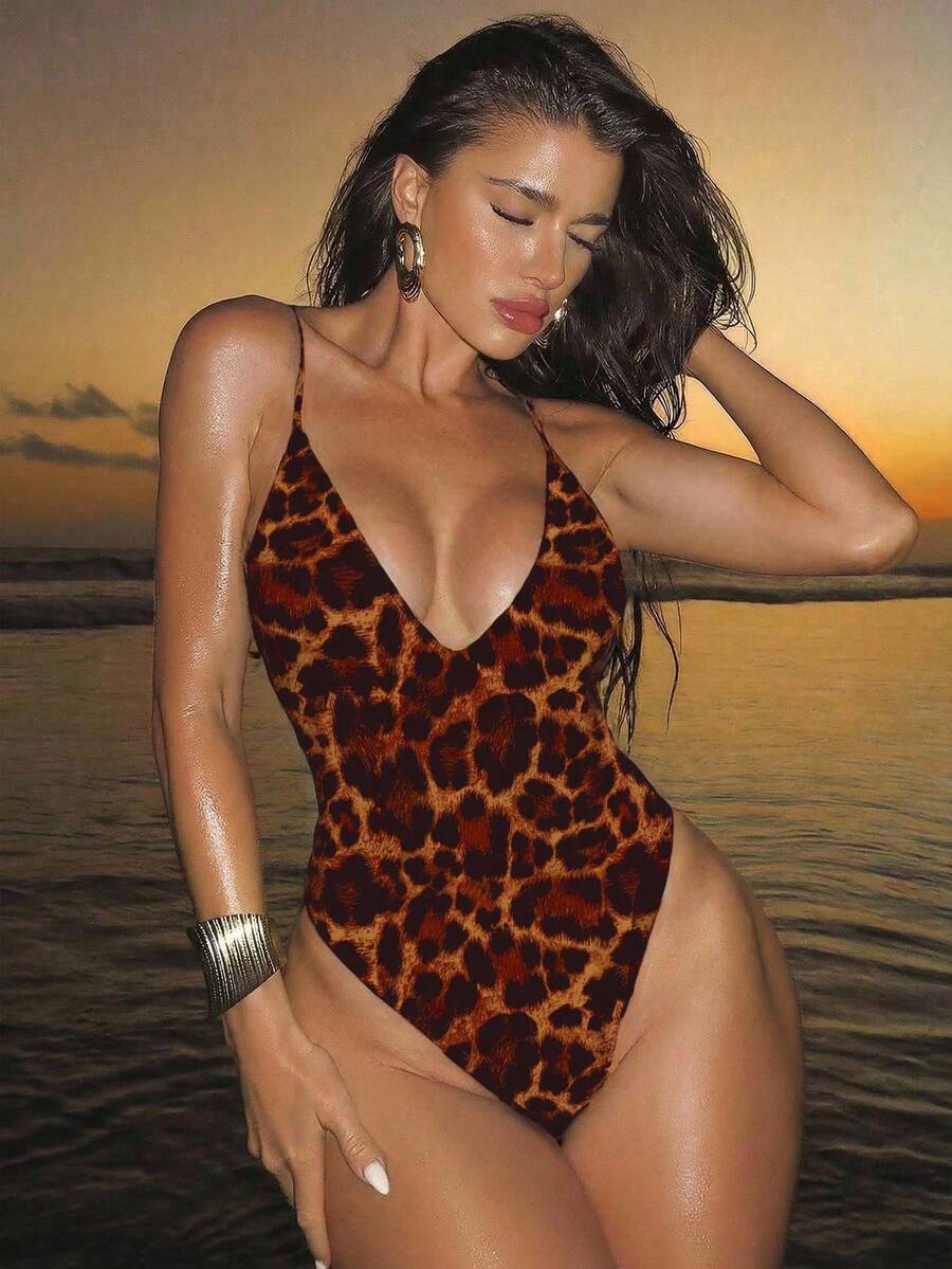 Women's black lace one-piece swimsuit featuring a deep V-neckline, spaghetti straps, backless tie-up detail, and thong bottom.