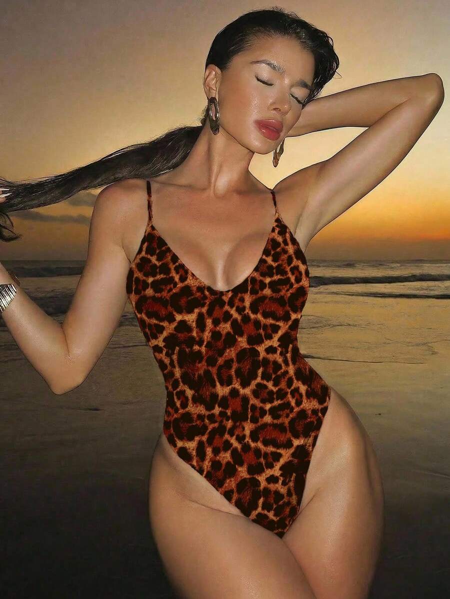 Women's black lace one-piece swimsuit featuring a deep V-neckline, spaghetti straps, backless tie-up detail, and thong bottom.