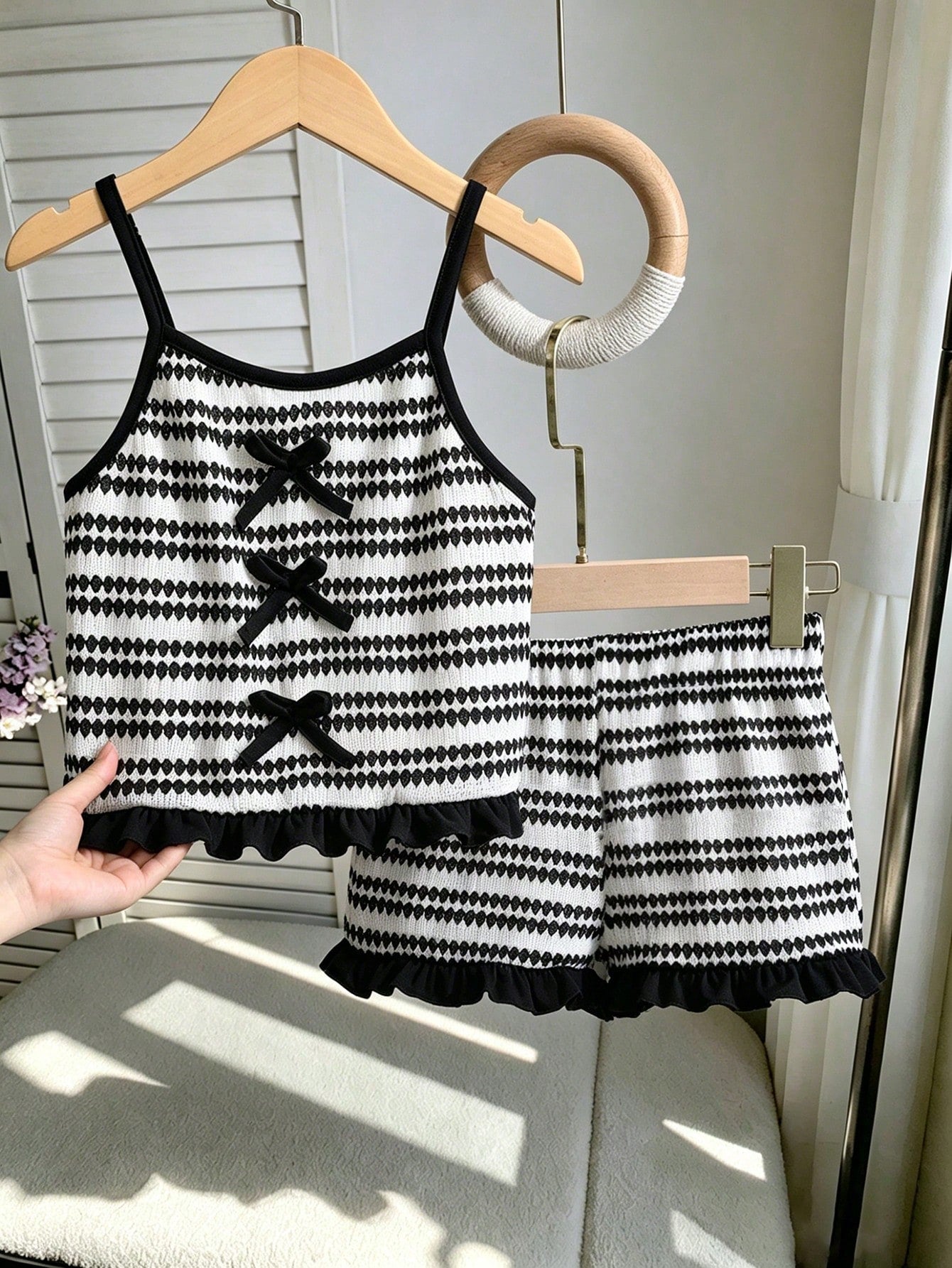Tween girls black and white striped two-piece set featuring a spaghetti strap micro crop tank top with lettuce trim and ruffle hem paired with matching slim fit shorts.
