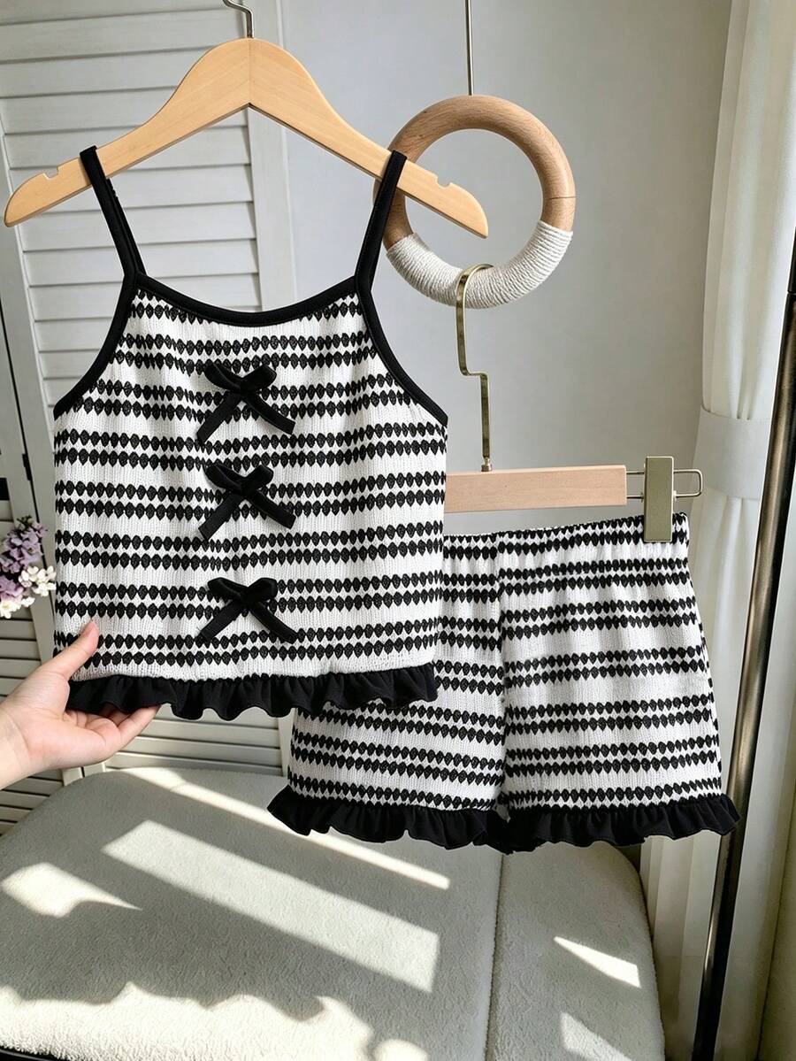 Tween girls black and white striped two-piece set featuring a spaghetti strap micro crop tank top with lettuce trim and ruffle hem paired with matching slim fit shorts.