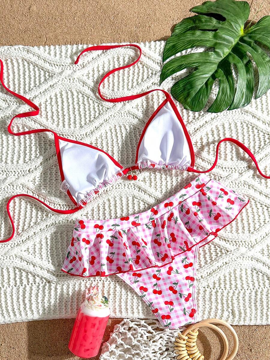 Women's 70s retro black and white polka dot bikini set featuring a halter triangle top and ultra low waist bottoms.