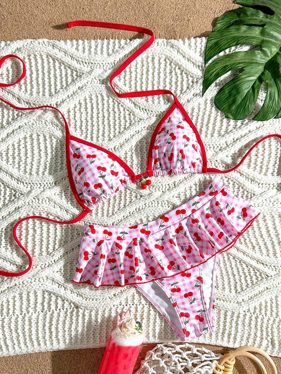 Women's 70s retro black and white polka dot bikini set featuring a halter triangle top and ultra low waist bottoms.