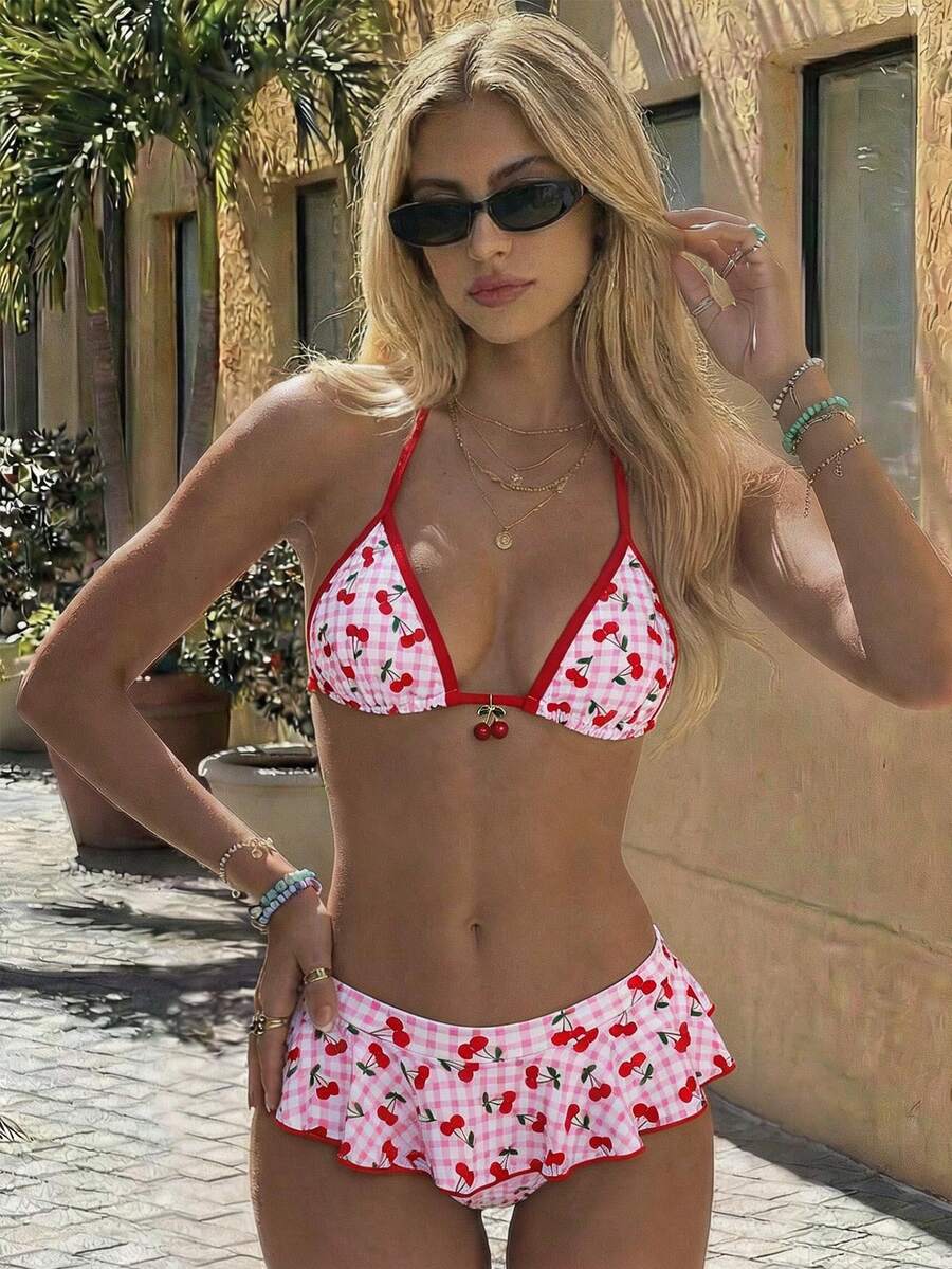 Women's 70s retro black and white polka dot bikini set featuring a halter triangle top and ultra low waist bottoms.