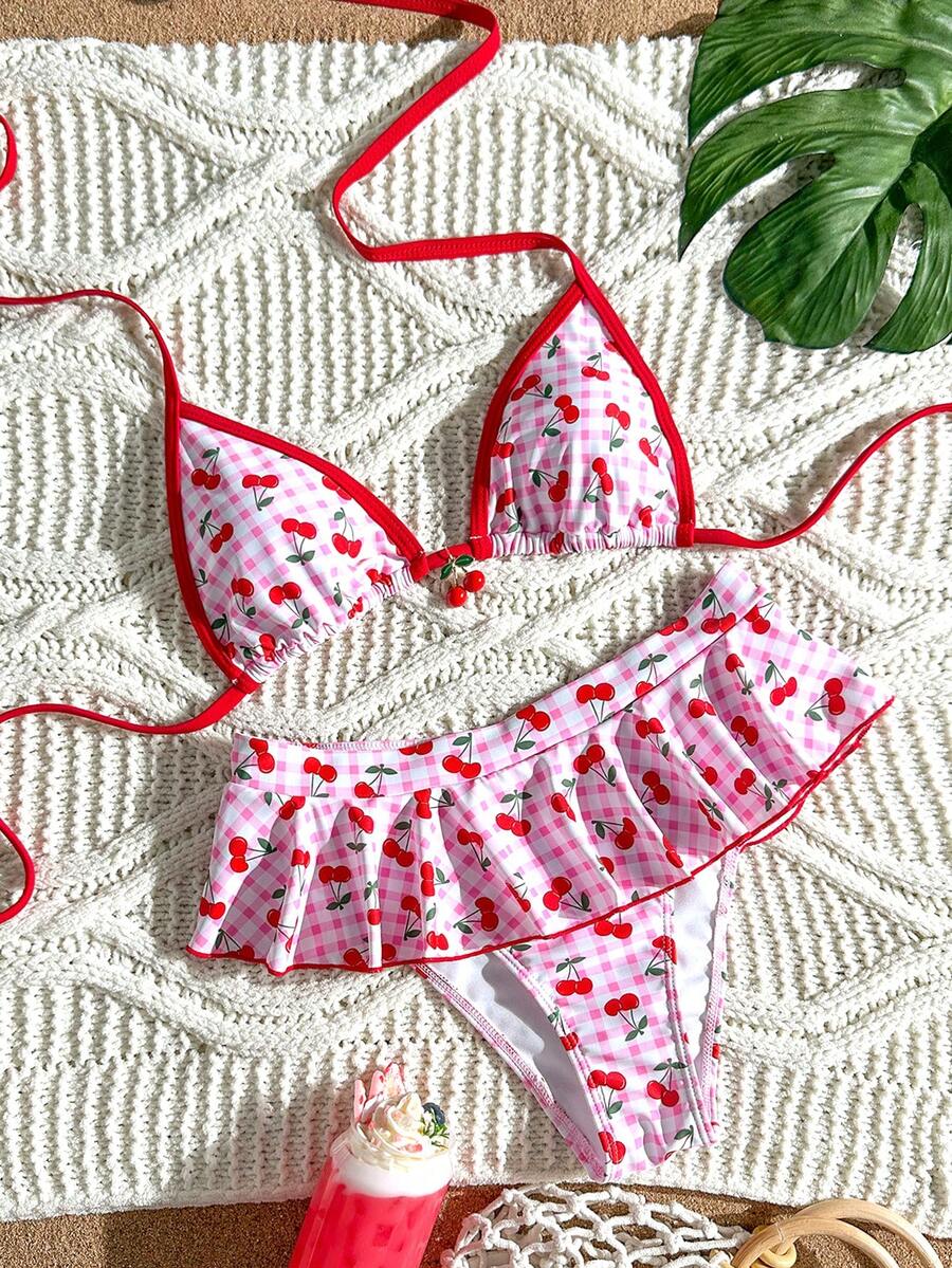 Women's 70s retro black and white polka dot bikini set featuring a halter triangle top and ultra low waist bottoms.