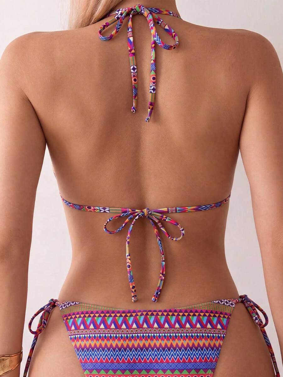Women's black two-piece bikini set featuring a halter neck with a colorful sun pendant, triangle cups, and high-cut tie-side bottoms.