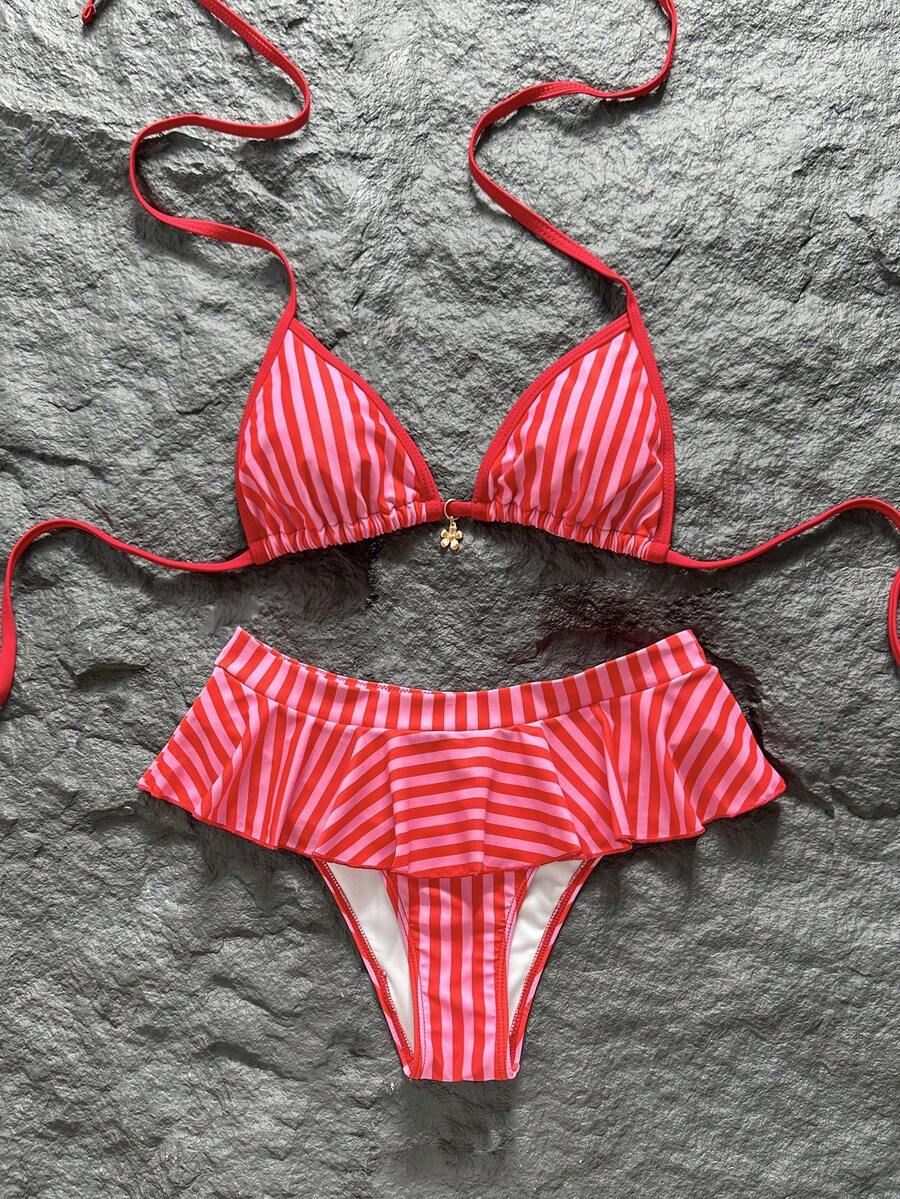 Women's 70s retro black and white polka dot bikini set featuring a halter triangle top and ultra low waist bottoms.
