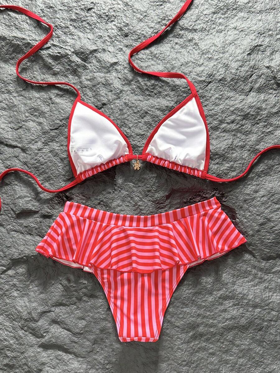 Women's 70s retro black and white polka dot bikini set featuring a halter triangle top and ultra low waist bottoms.
