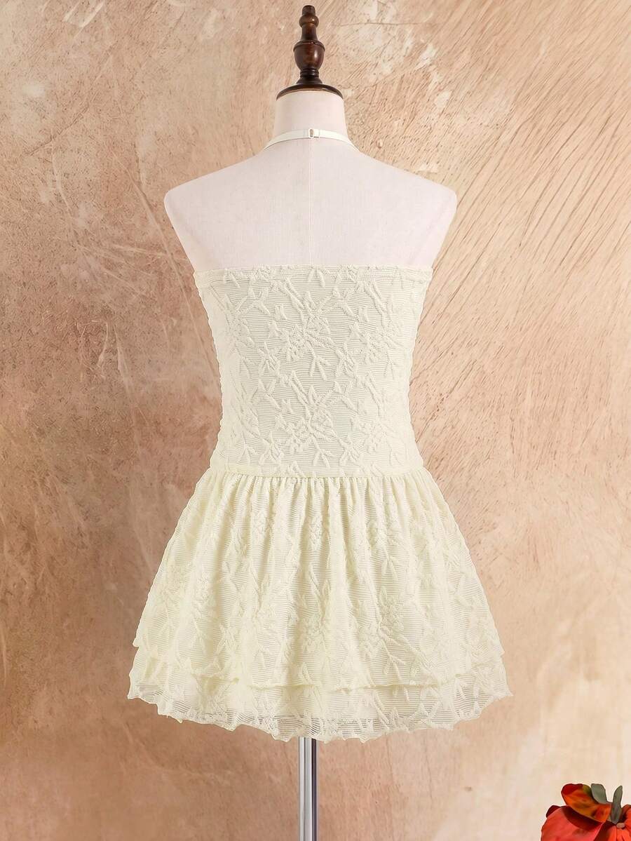 Tween girl black mini dress with halter neckline, backless design, tiered layer detail, high waist, flounce hem, and sleeveless slim fit.