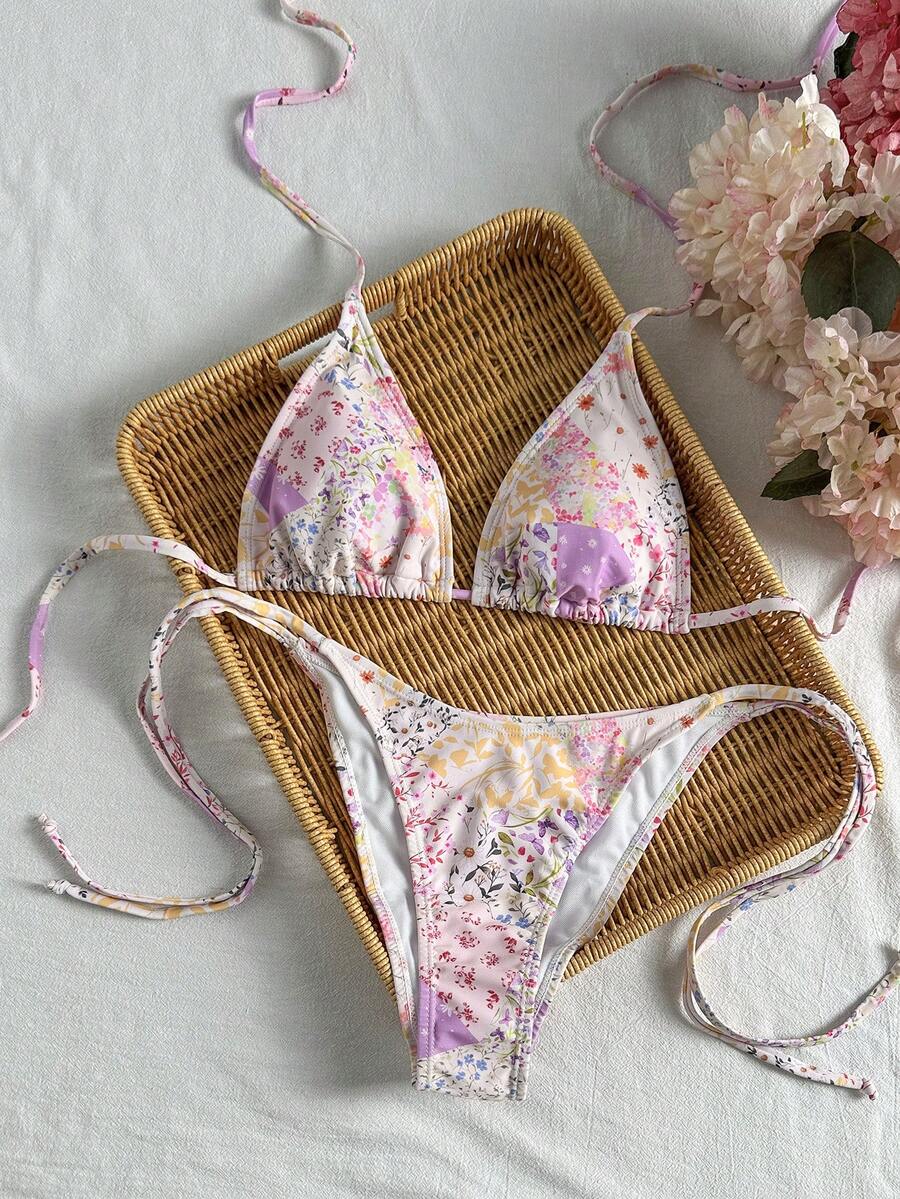 Women's black two-piece bikini set featuring a halter neck with a colorful sun pendant, triangle cups, and high-cut tie-side bottoms.