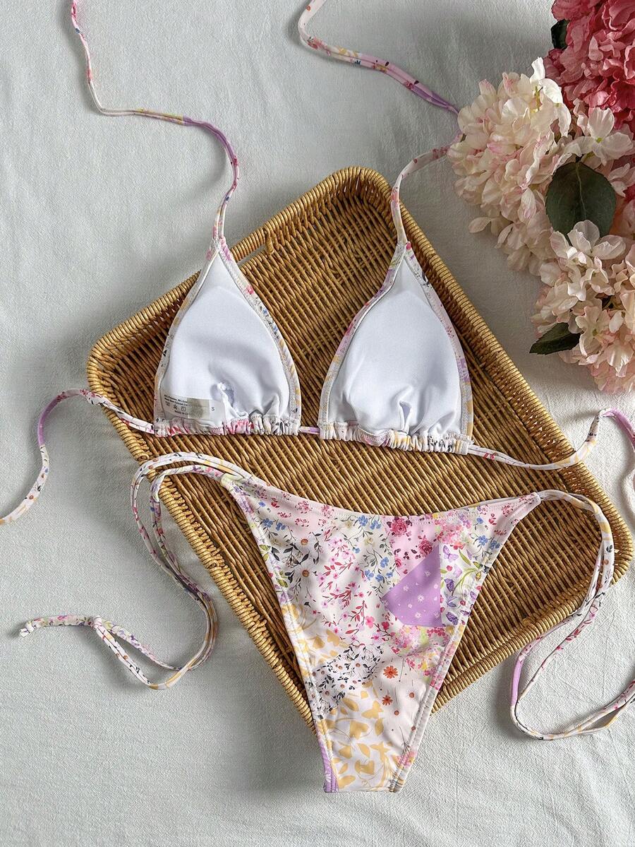 Women's black two-piece bikini set featuring a halter neck with a colorful sun pendant, triangle cups, and high-cut tie-side bottoms.