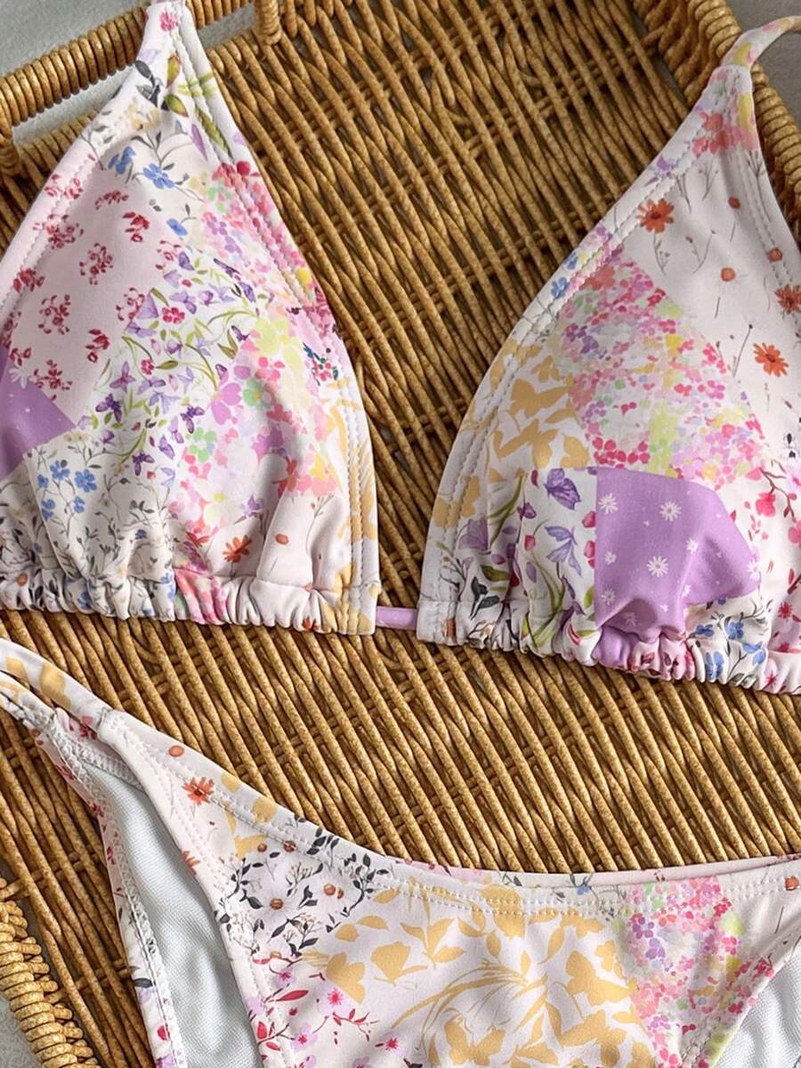 Women's black two-piece bikini set featuring a halter neck with a colorful sun pendant, triangle cups, and high-cut tie-side bottoms.