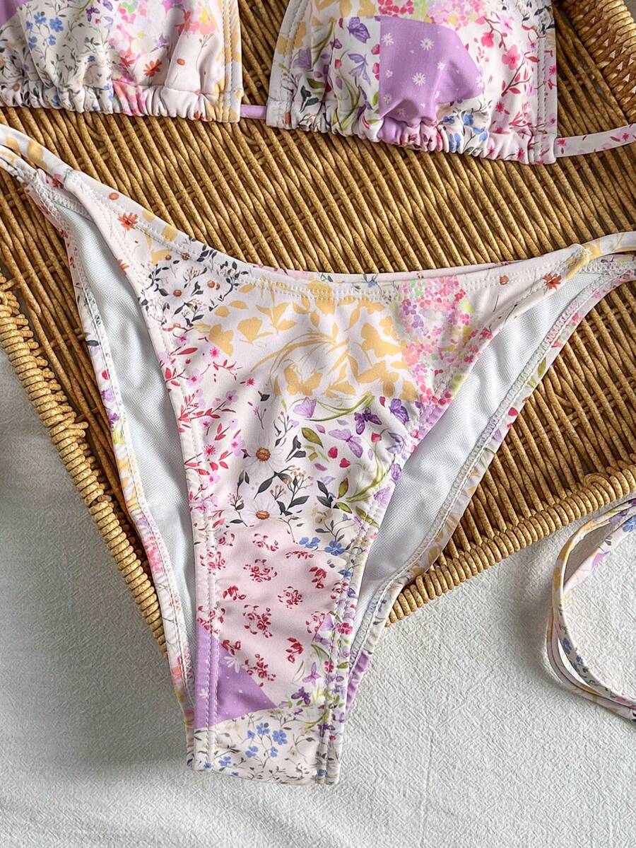 Women's black two-piece bikini set featuring a halter neck with a colorful sun pendant, triangle cups, and high-cut tie-side bottoms.