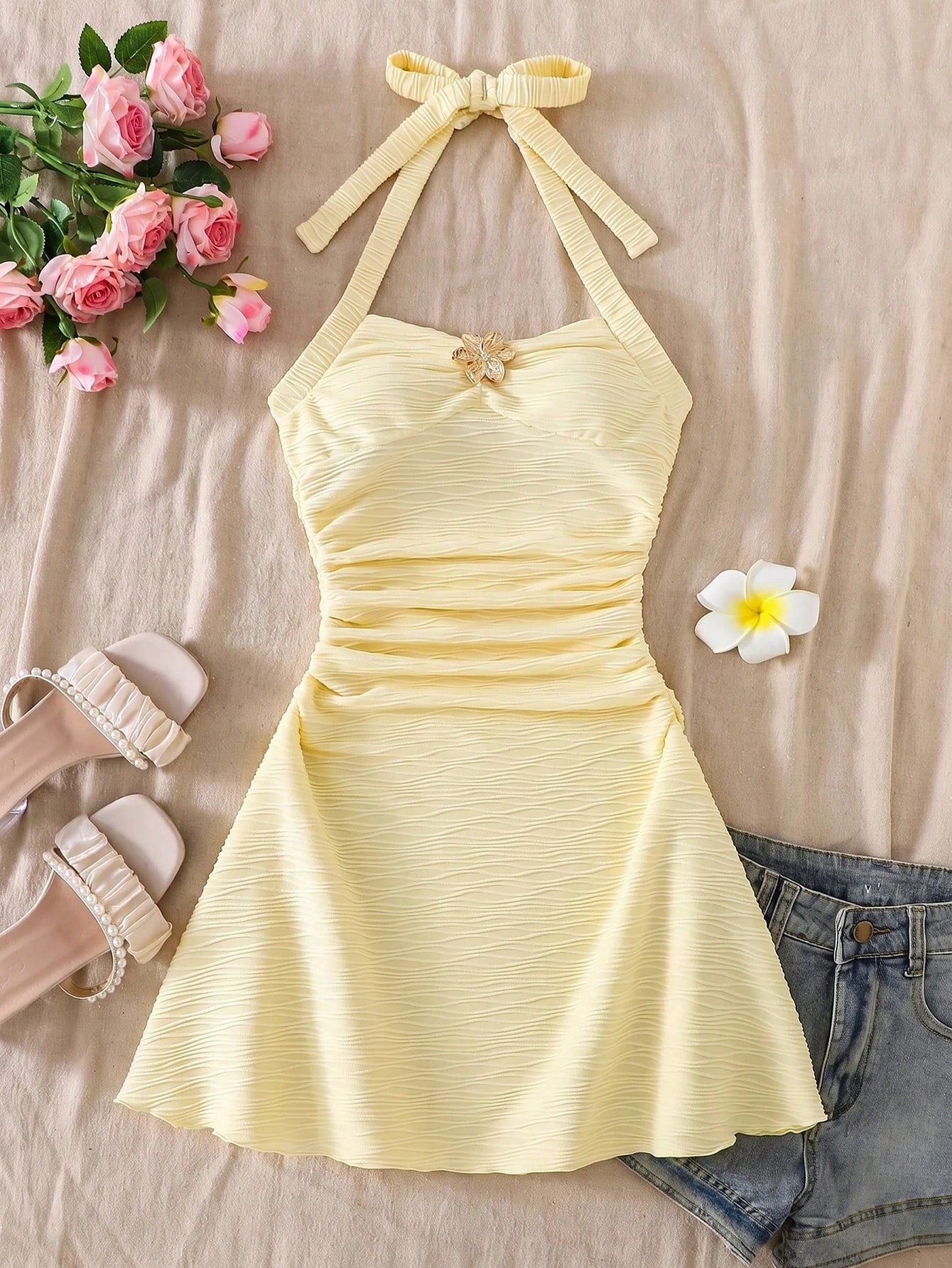 Tween girl yellow mini sundress with large pink floral hibiscus print, spaghetti straps, high waist, flared hem, and sleeveless cami style for summer beach wear