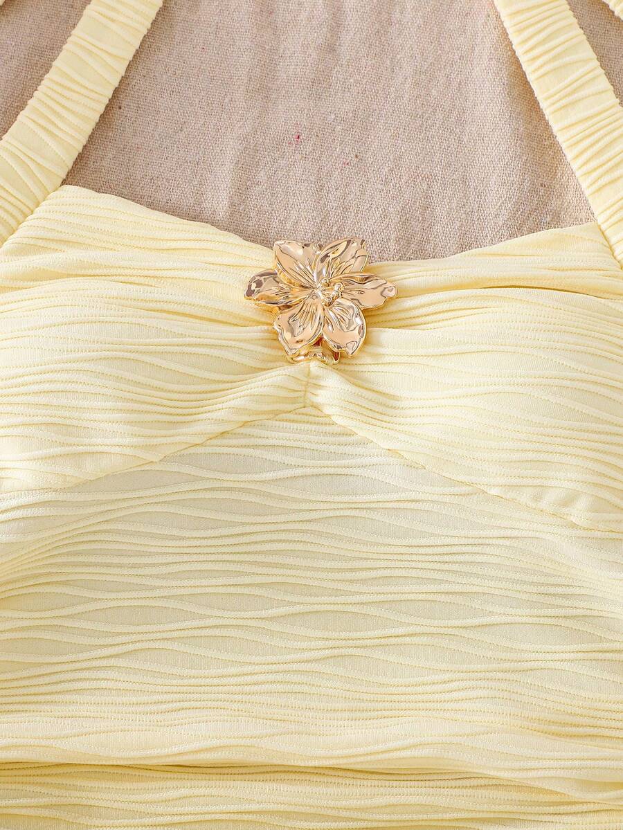 Tween girl yellow mini sundress with large pink floral hibiscus print, spaghetti straps, high waist, flared hem, and sleeveless cami style for summer beach wear
