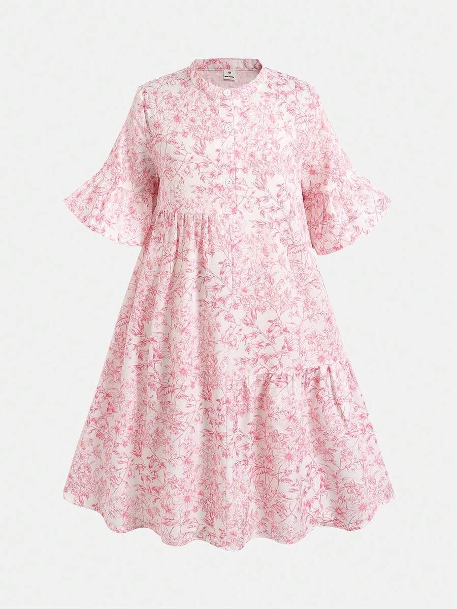 Tween girl wearing a black striped smock shirt dress with flounce half sleeves, a stand collar, and a ruffled hem.