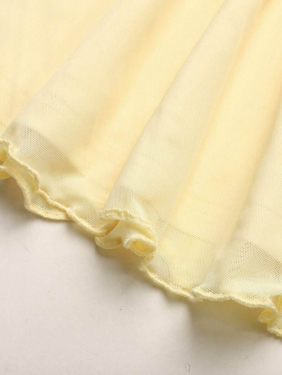 Tween girl wearing an apricot asymmetrical tiered sleeveless party dress with an A-line silhouette.