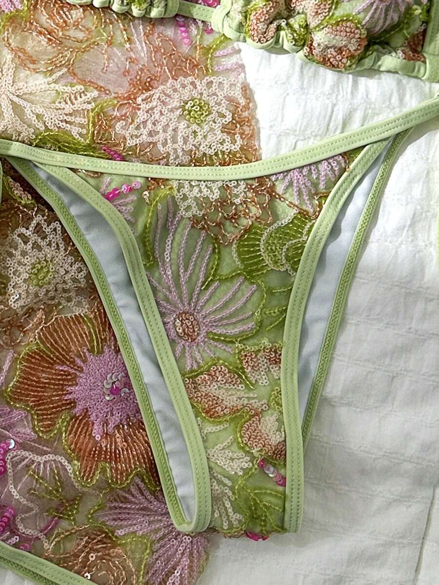 Women's 3-piece blue tropical shell print bikini set featuring a halter bralette top, low-waist tie-side bottom, and a matching sheer mesh cover-up skirt.