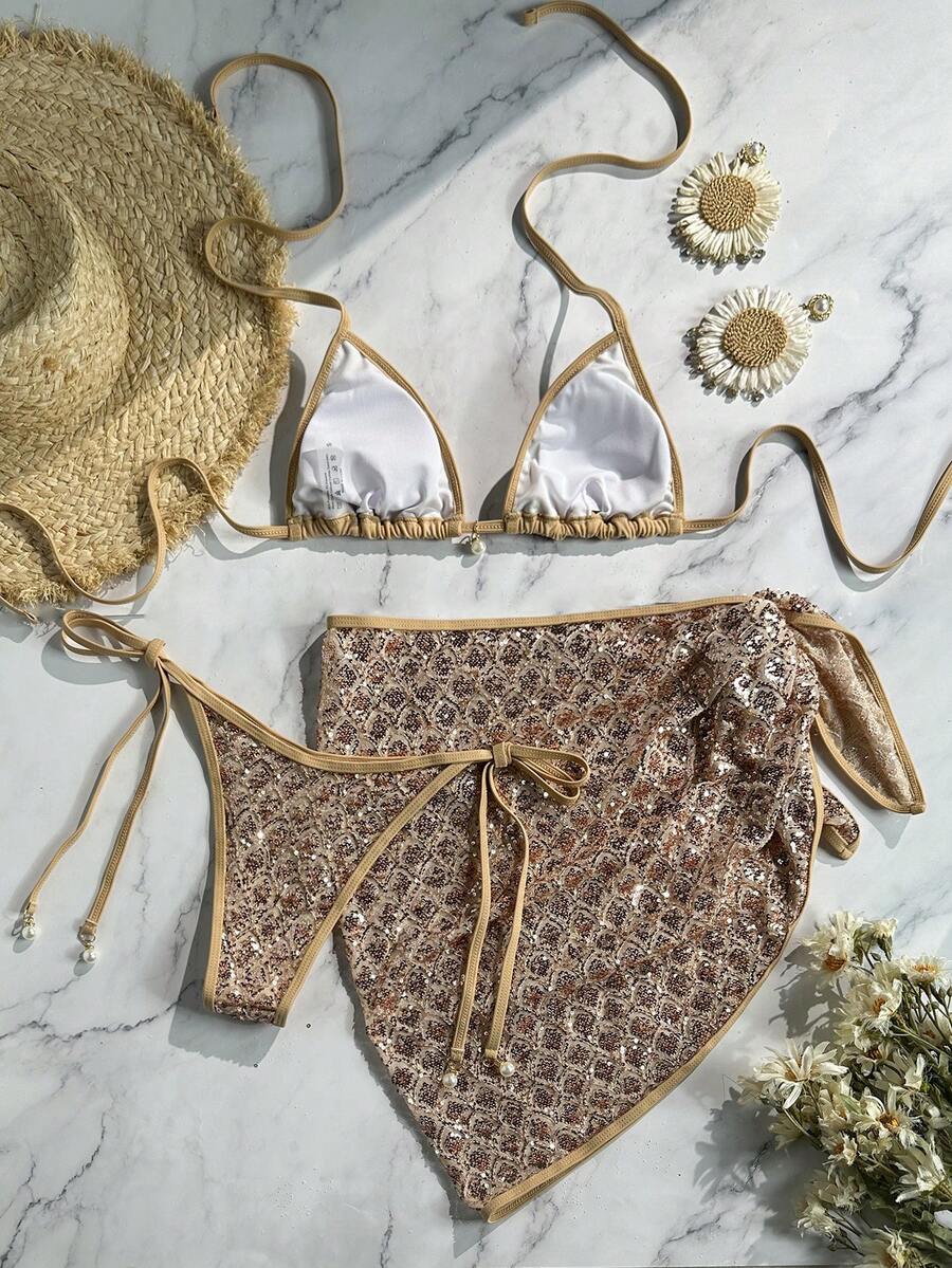 Women's 3-piece blue tropical shell print bikini set featuring a halter bralette top, low-waist tie-side bottom, and a matching sheer mesh cover-up skirt.