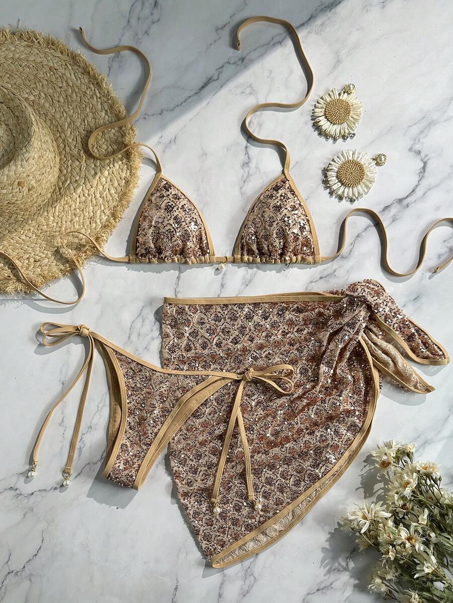 Women's 3-piece blue tropical shell print bikini set featuring a halter bralette top, low-waist tie-side bottom, and a matching sheer mesh cover-up skirt.