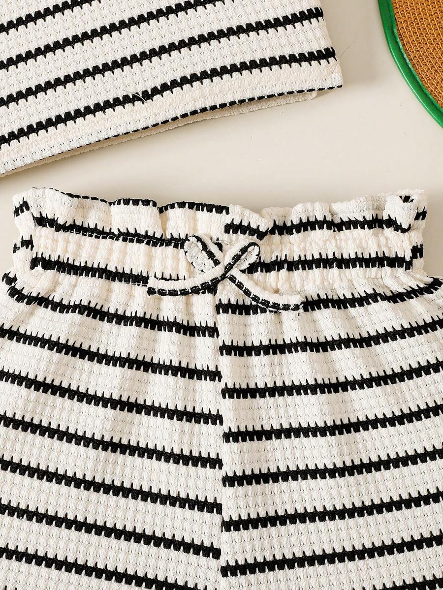 Black and white striped 2-piece set for tween girls featuring a halter sleeveless pullover top with criss-cross knot detail and matching paperbag waist shorts.