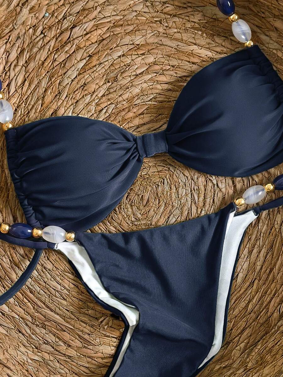 Women's green halter neck bikini set featuring color-block beaded shoulder straps, back tie detail, and high cut bottoms.