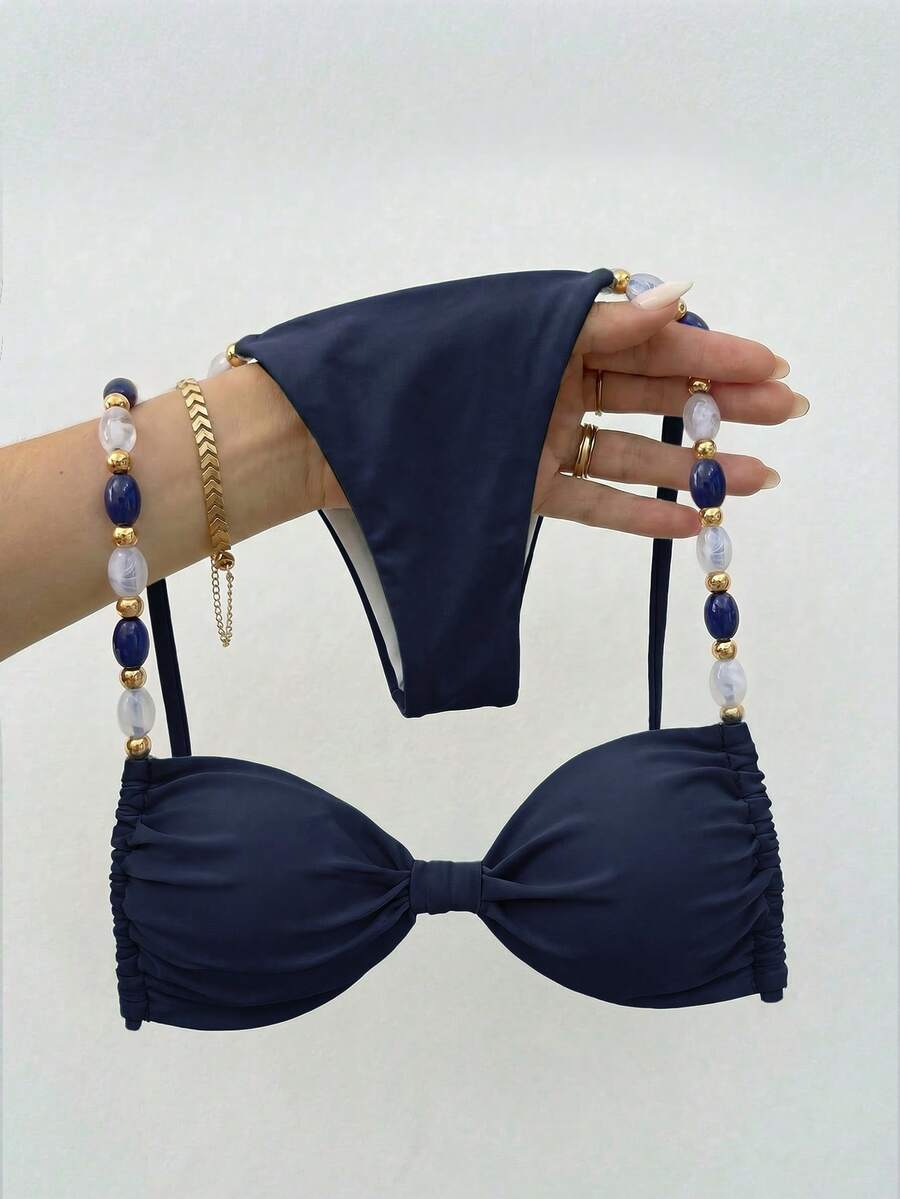 Women's green halter neck bikini set featuring color-block beaded shoulder straps, back tie detail, and high cut bottoms.