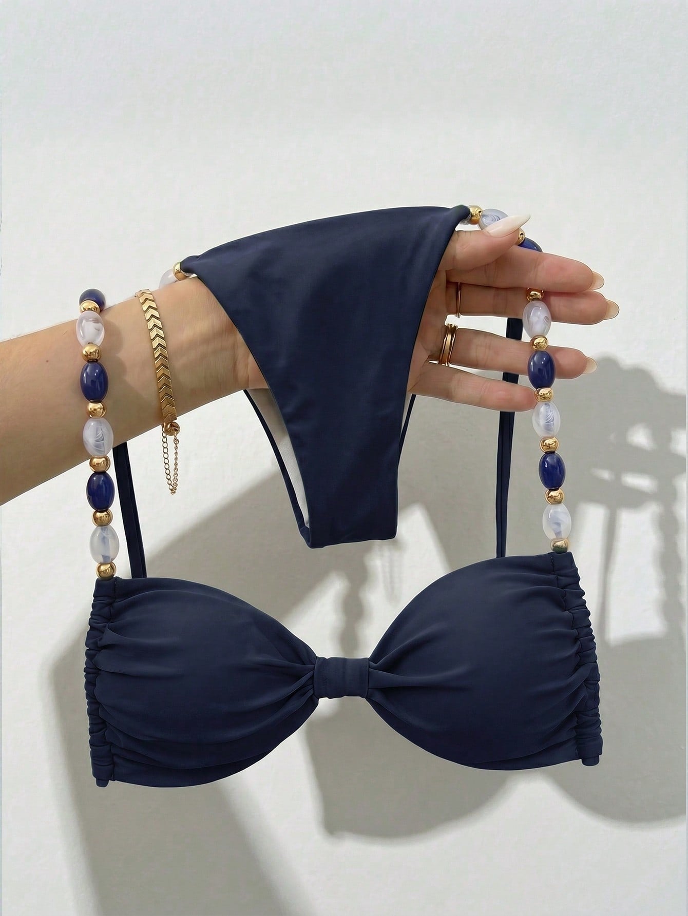 Women's green halter neck bikini set featuring color-block beaded shoulder straps, back tie detail, and high cut bottoms.