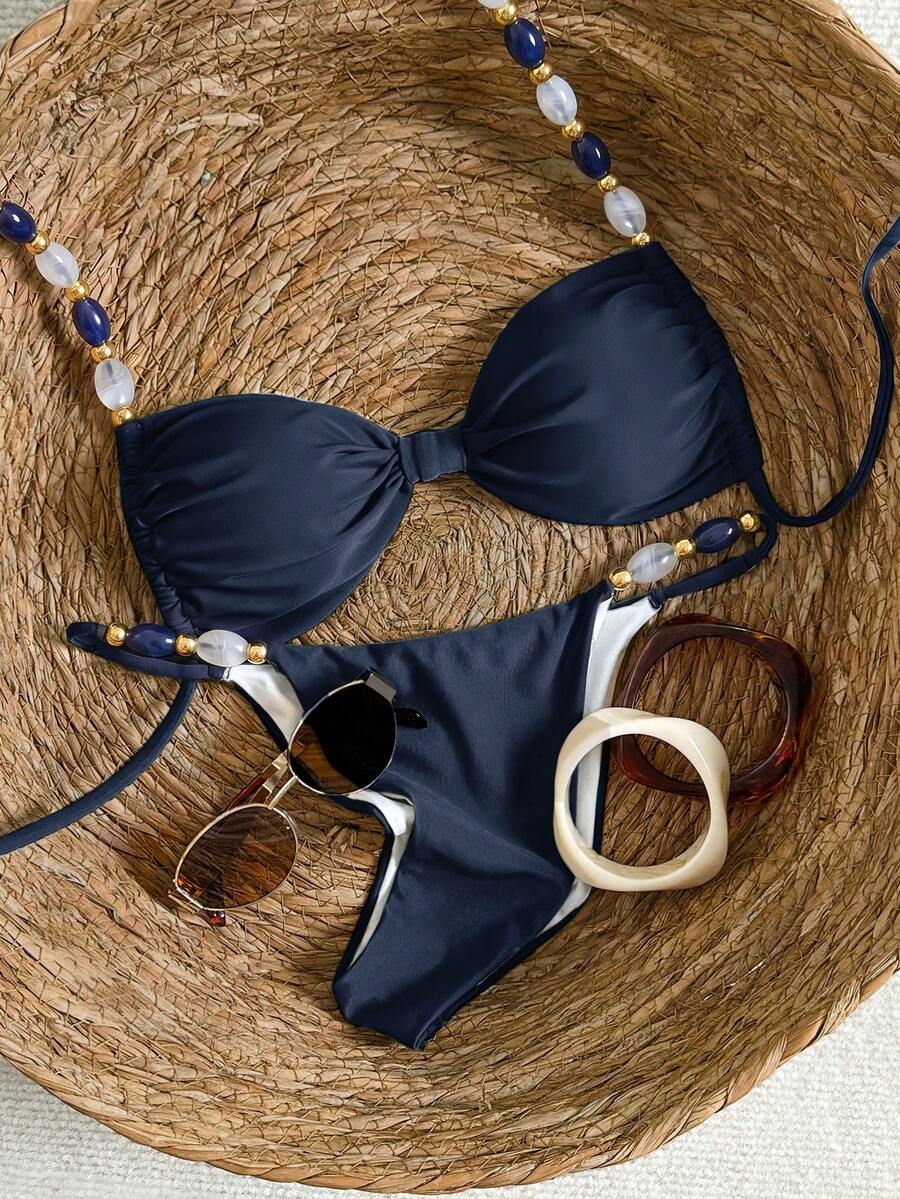 Women's green halter neck bikini set featuring color-block beaded shoulder straps, back tie detail, and high cut bottoms.