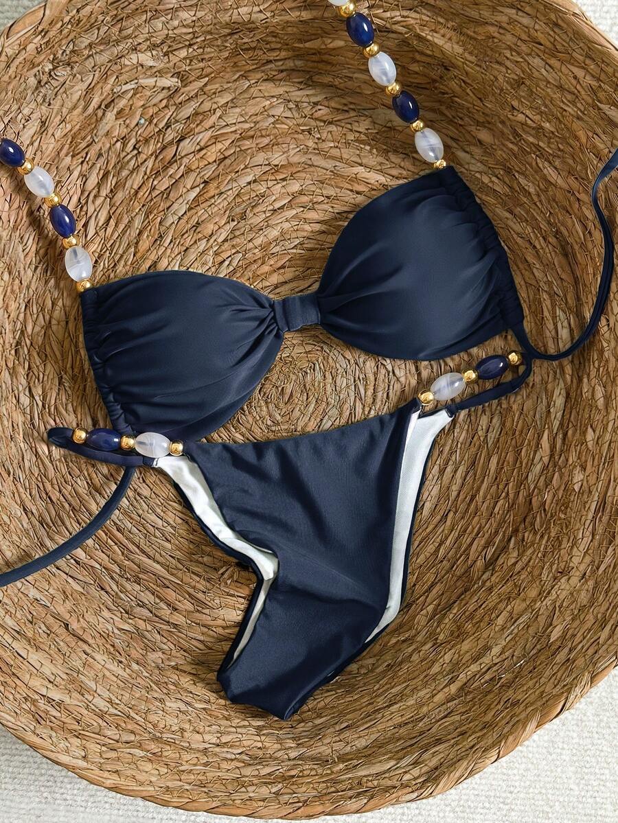 Women's green halter neck bikini set featuring color-block beaded shoulder straps, back tie detail, and high cut bottoms.