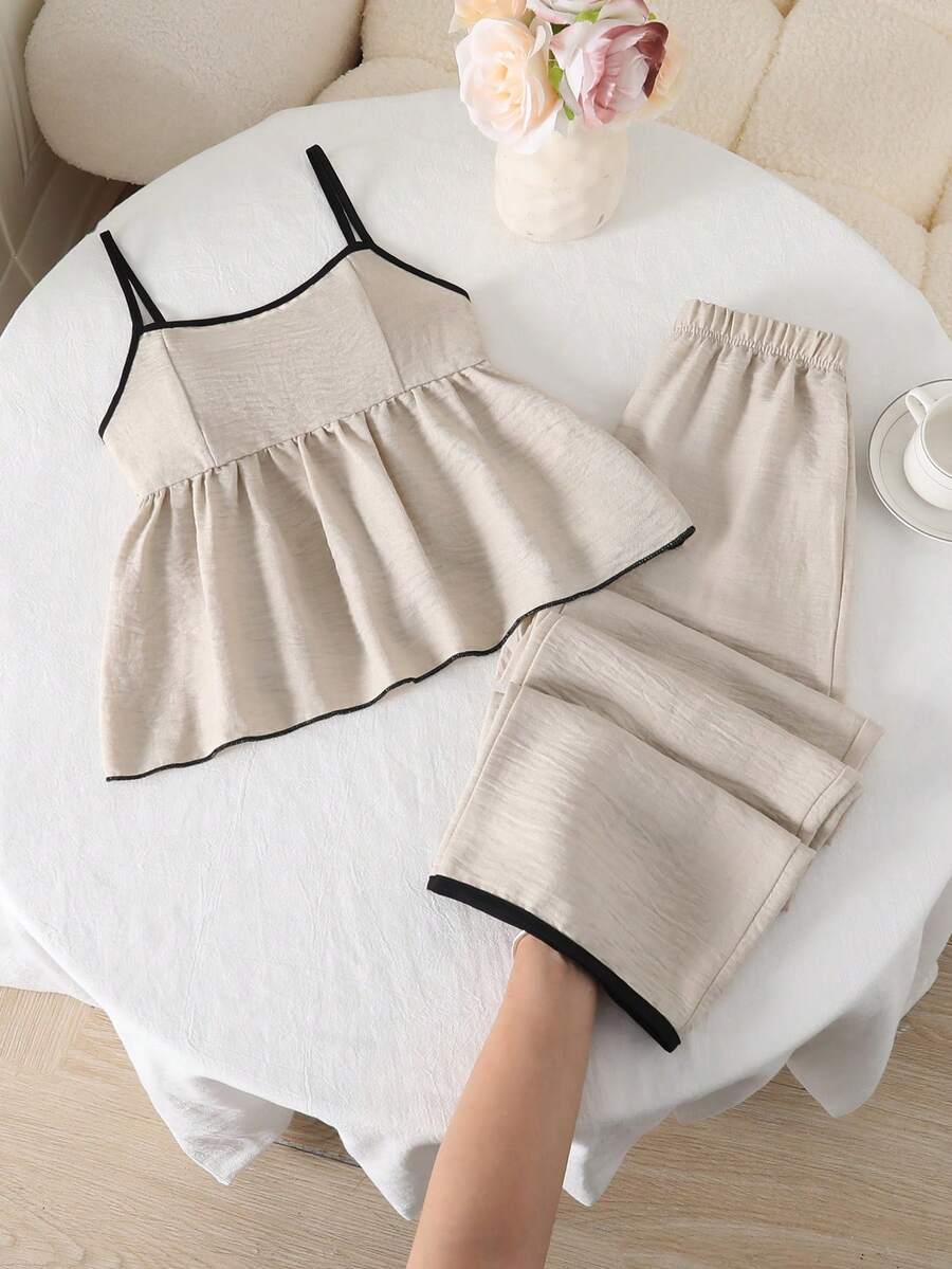 Tween girl wearing an apricot 2-piece outfit set featuring a shirred spaghetti strap short cami top and matching wide-leg long pants.