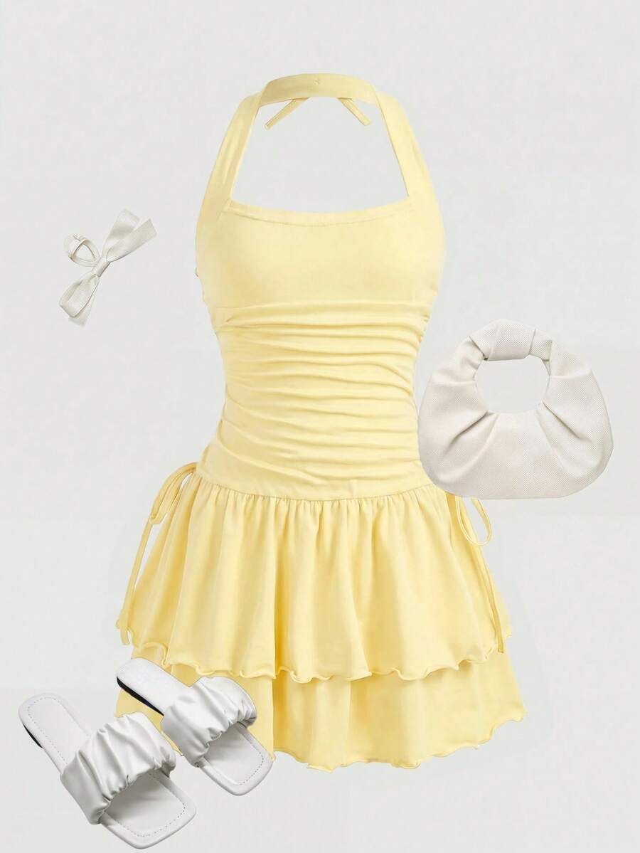 Black sleeveless halter polka dot mini dress for tween girls featuring a high waist and flared hem