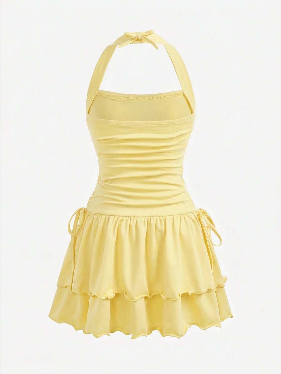 Black sleeveless halter polka dot mini dress for tween girls featuring a high waist and flared hem