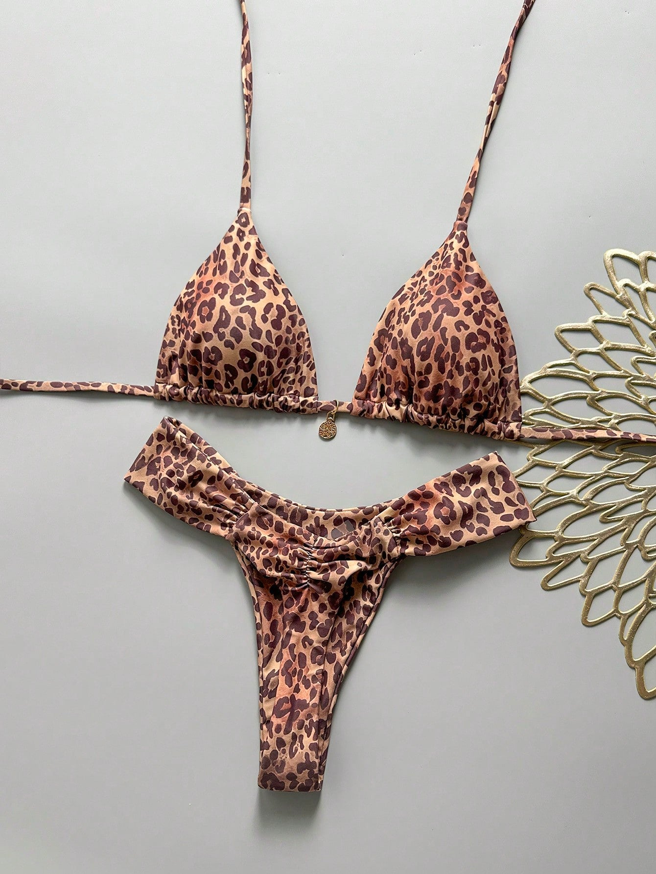 Women's 2-piece triangle cup bikini set in solid color featuring woven pearl shell decoration, halter neckline, and high-waist side-tie ruched bottoms.