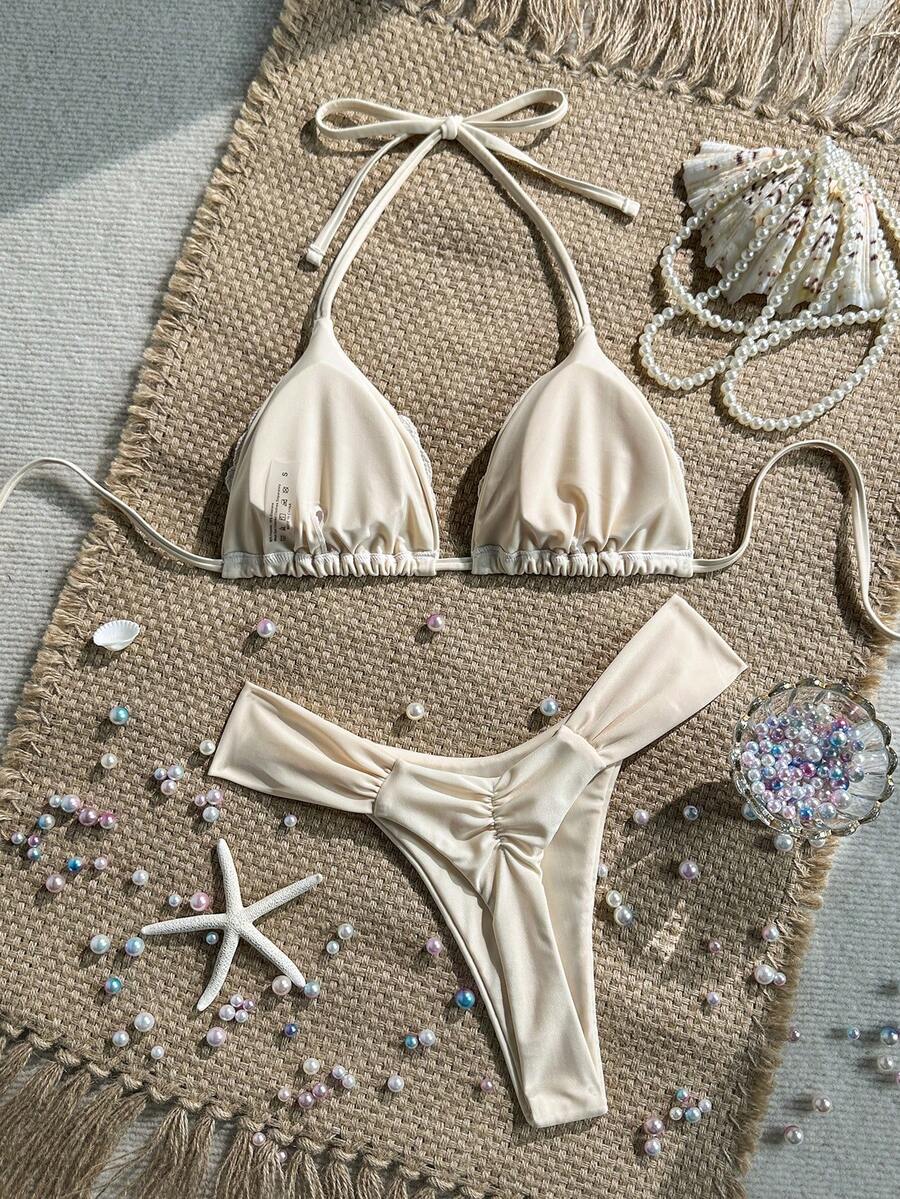 Women's 2-piece triangle cup bikini set in solid color featuring woven pearl shell decoration, halter neckline, and high-waist side-tie ruched bottoms.