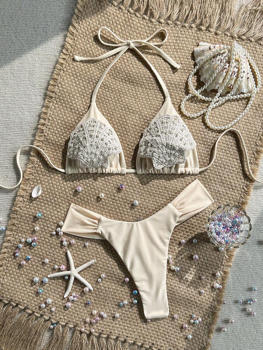 Women's 2-piece triangle cup bikini set in solid color featuring woven pearl shell decoration, halter neckline, and high-waist side-tie ruched bottoms.