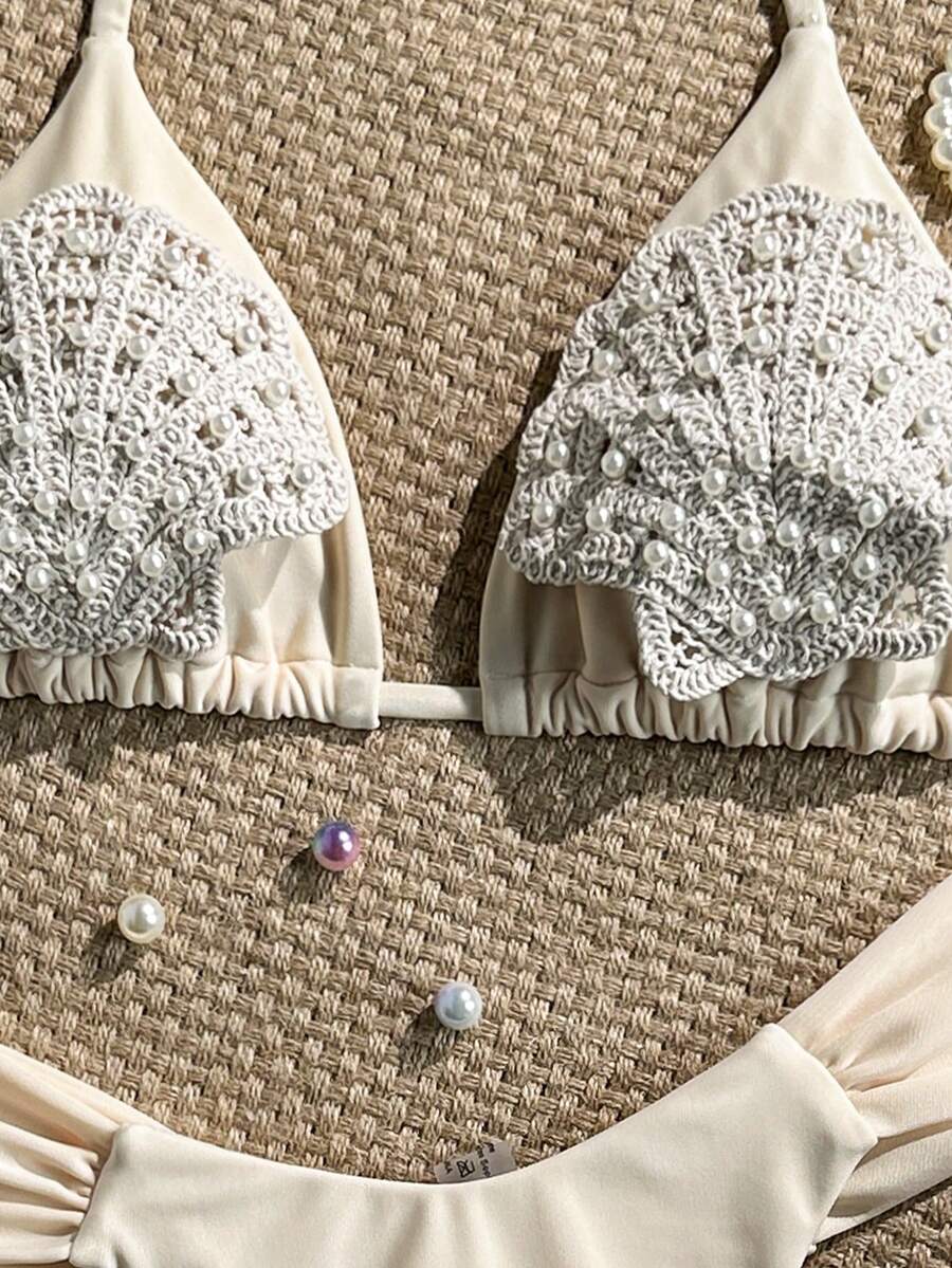 Women's 2-piece triangle cup bikini set in solid color featuring woven pearl shell decoration, halter neckline, and high-waist side-tie ruched bottoms.