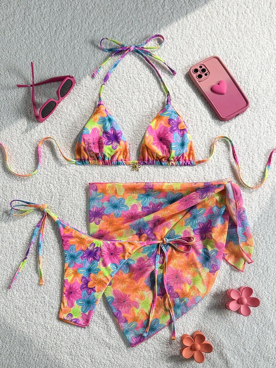 Women's 3-piece blue tropical shell print bikini set featuring a halter bralette top, low-waist tie-side bottom, and a matching sheer mesh cover-up skirt.