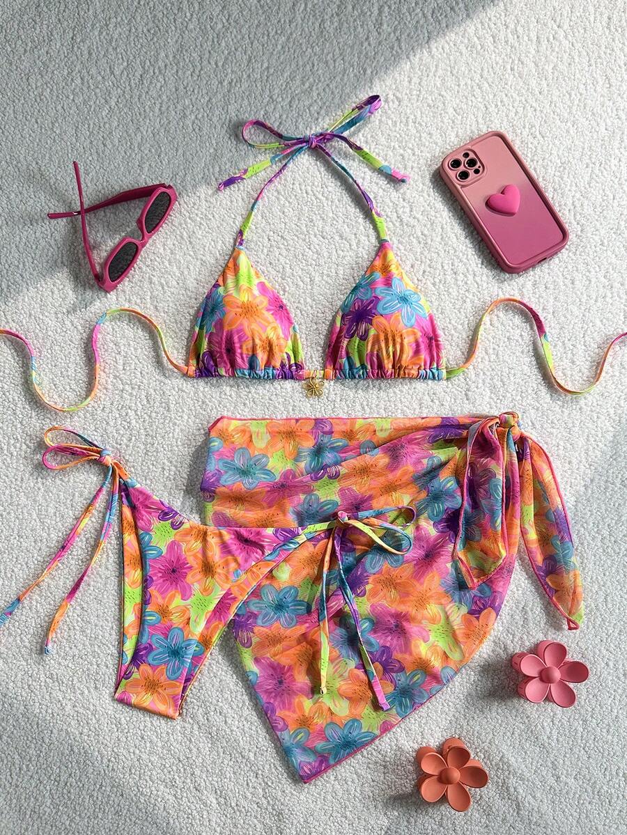 Women's 3-piece blue tropical shell print bikini set featuring a halter bralette top, low-waist tie-side bottom, and a matching sheer mesh cover-up skirt.