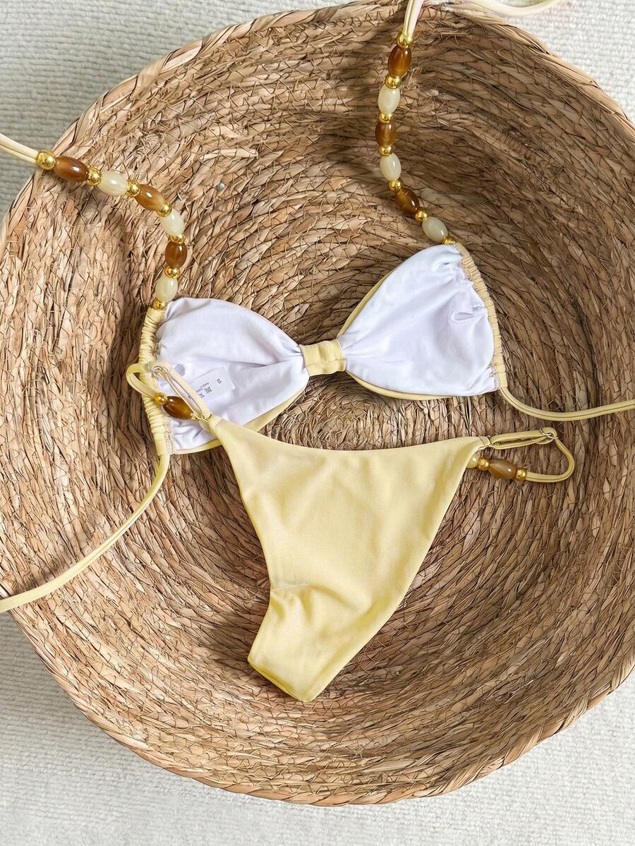 Women's green halter neck bikini set featuring color-block beaded shoulder straps, back tie detail, and high cut bottoms.