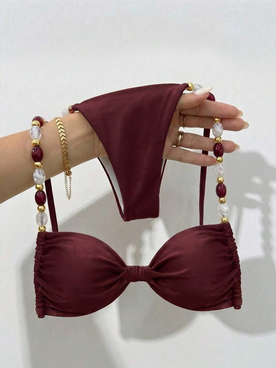 Women's green halter neck bikini set featuring color-block beaded shoulder straps, back tie detail, and high cut bottoms.
