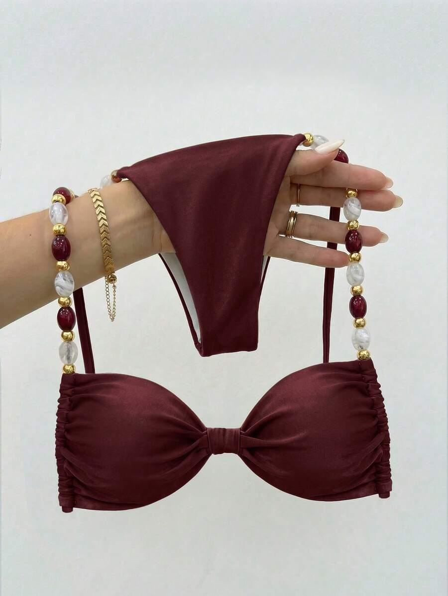 Women's green halter neck bikini set featuring color-block beaded shoulder straps, back tie detail, and high cut bottoms.