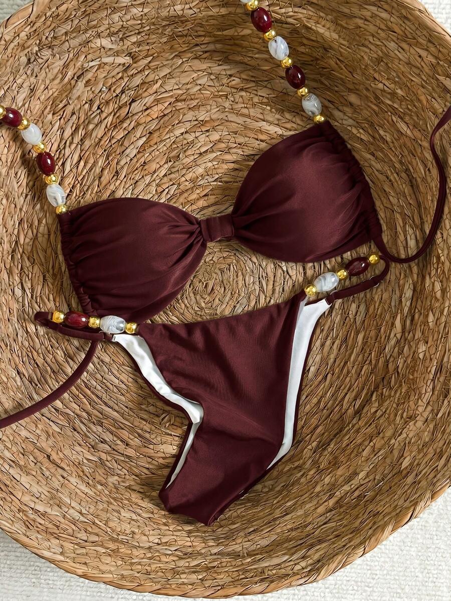Women's green halter neck bikini set featuring color-block beaded shoulder straps, back tie detail, and high cut bottoms.