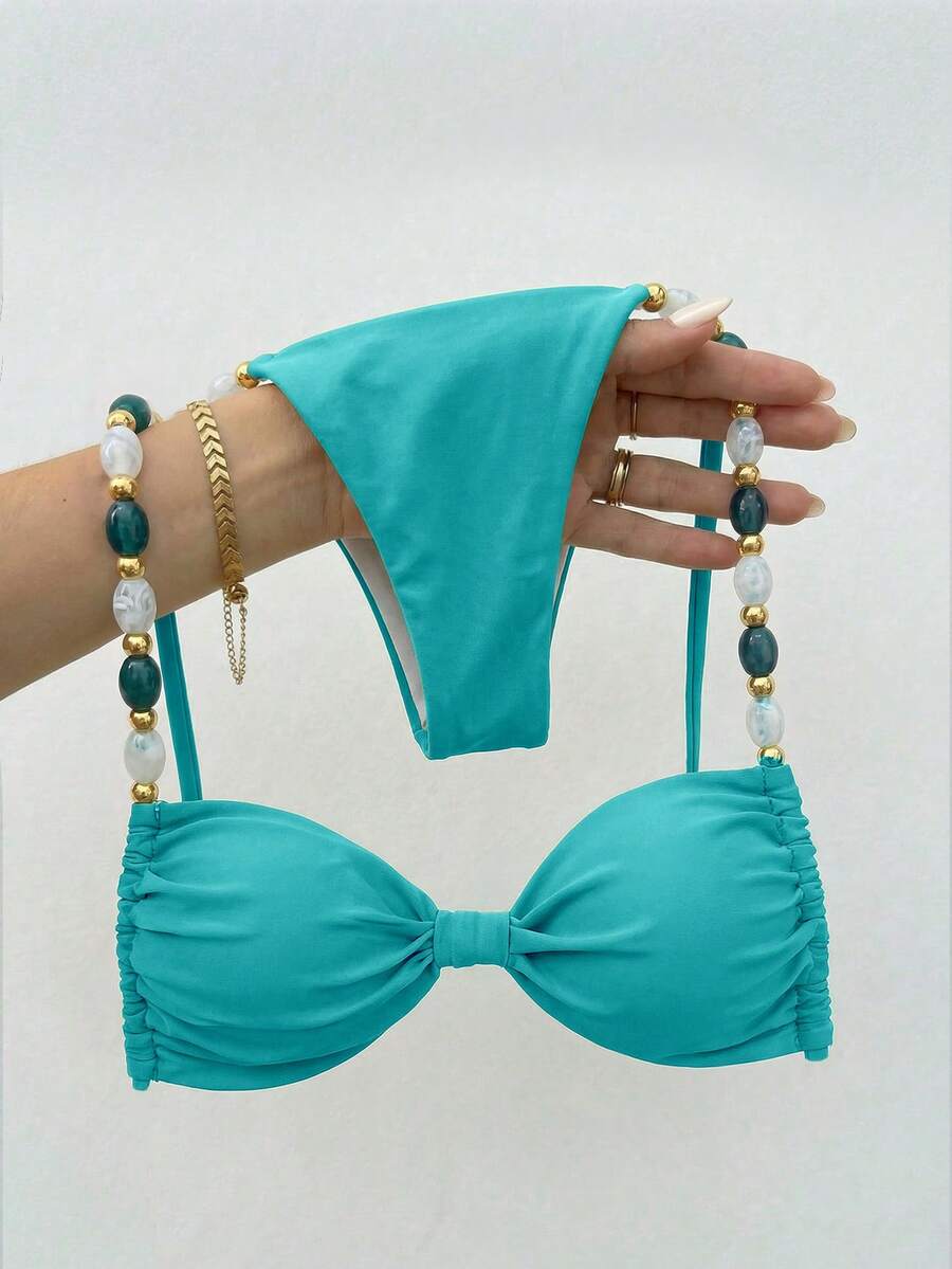 Women's green halter neck bikini set featuring color-block beaded shoulder straps, back tie detail, and high cut bottoms.